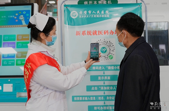 導(dǎo)診員指導(dǎo)患者掃就醫(yī)碼“一碼通”（攝影：陳影）.jpg